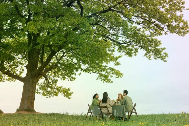 Happy people in nature under a large tree